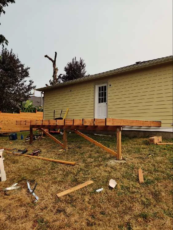 Raised wood deck frame with posts, beams and temporary bracing