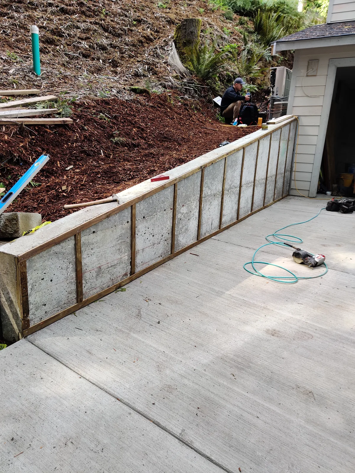 Poured concrete retaining wall structure along a graded residential site