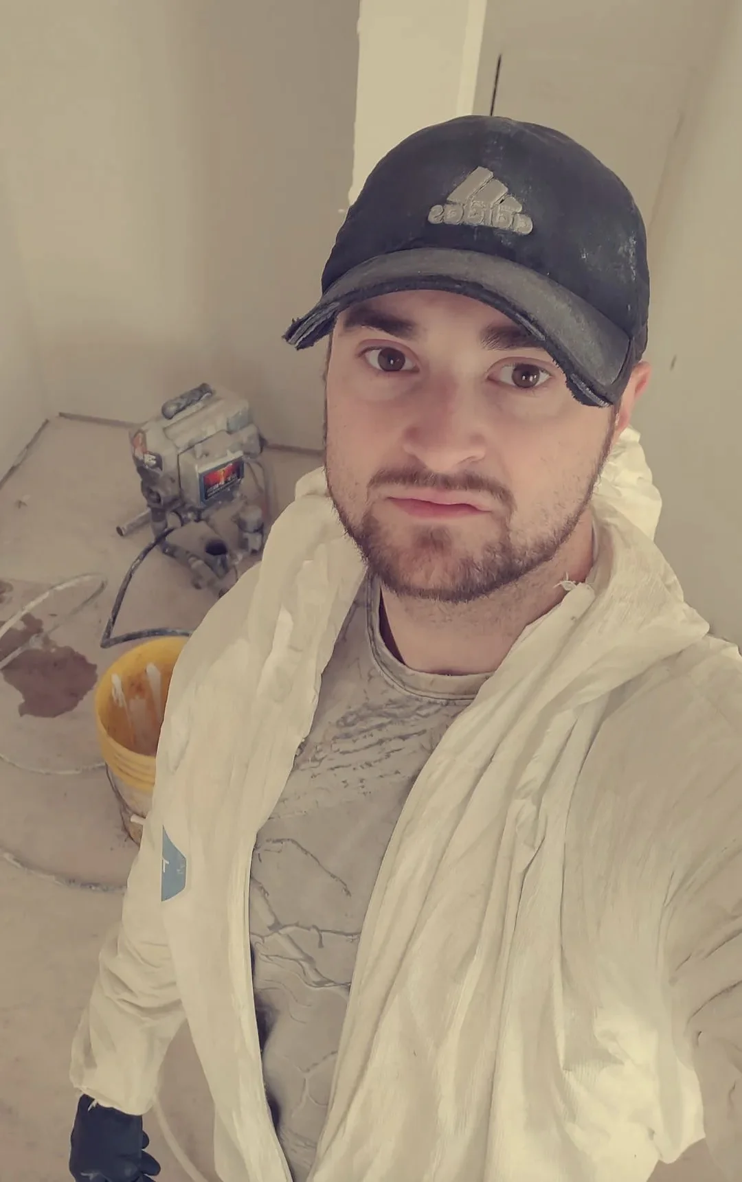 Contractor wearing protective coveralls while preparing to prime the interior of his second house