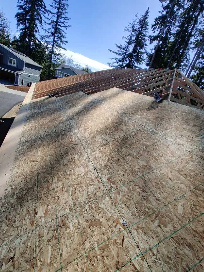 OSB roof sheathing progressing across exposed wood trusses