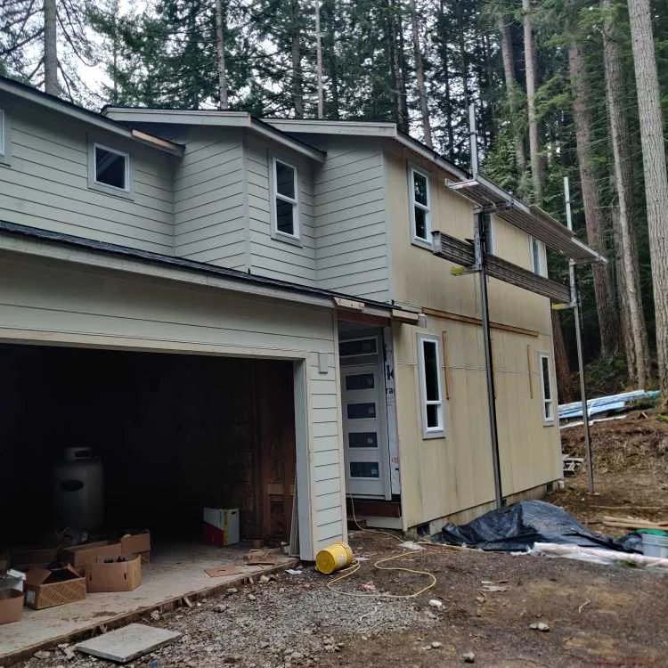Two-story house exterior during a siding installation project