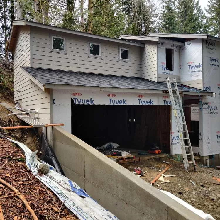 Horizontal siding installation in progress on a two-story house